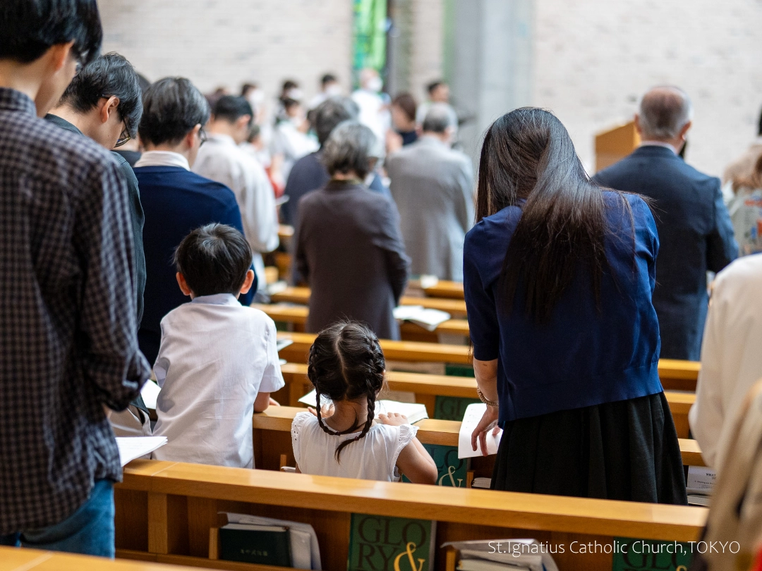 10/18(日)10:00- 年間第29主日 幼児洗礼式 会衆席の親子。父母の間に小さな男の子と女の子