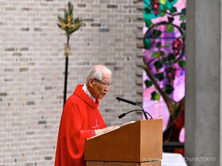 3/29(日)10:00- 受難の主日(枝の主日) 司式の髙祖神父と棕櫚の葉が掲げられた十字架