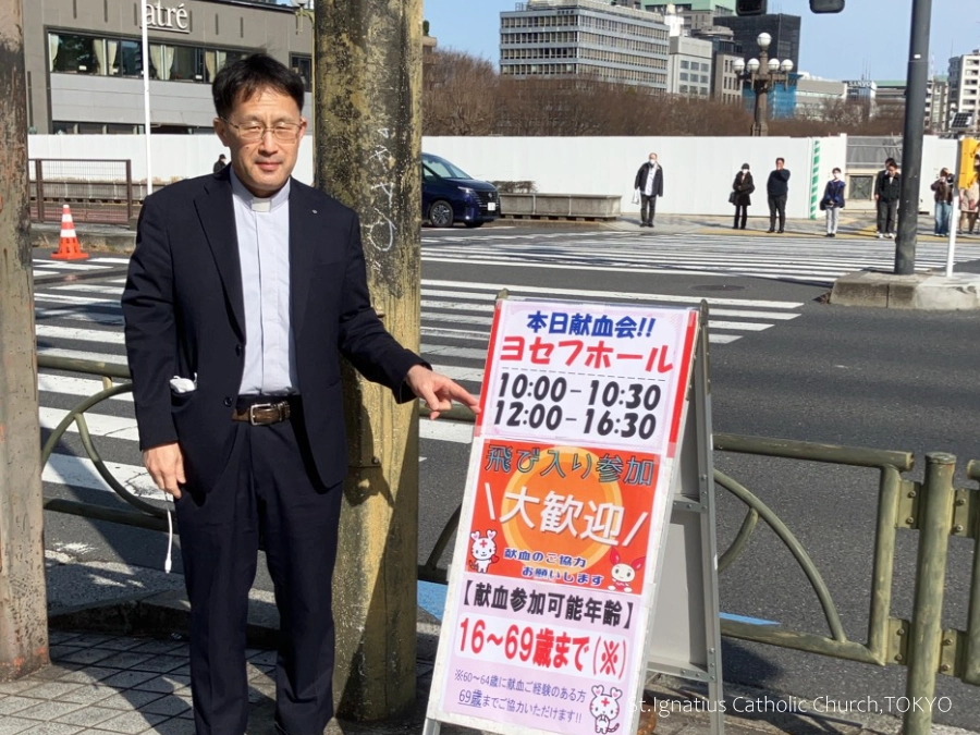 3/1(日)10:00- 四旬節第2主日 春の献血会 四ツ谷駅交差点前の立て看板と柴田神父